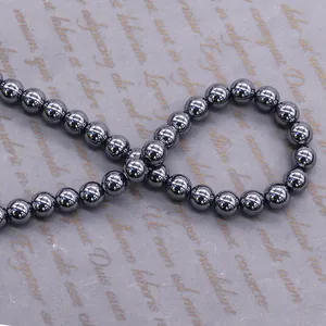Deep grey terahertz beads with metallic luster on vintage textured paper background