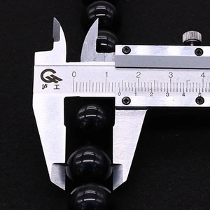 Detaillierte Messung einer 12mm Obsidianperle mit einem Metall-Messschieber-Werkzeug