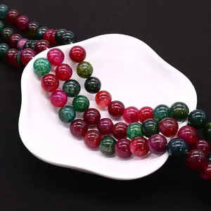 Polished natural tourmaline agate beads with dragon pattern texture on a white plate