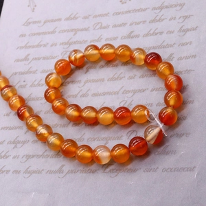 Natural red agate round beads for DIY jewelry making on vintage script background