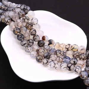 Polished natural dragon vein agate round beads for DIY jewelry making in a white plate