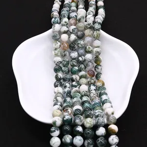 Natural round Moss Agate beads with green texture for DIY jewelry on white plate
