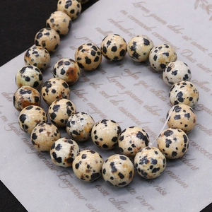 Natural Dalmatian Jasper round beads for DIY jewelry making on decorative paper