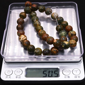 Vue macro de perles en pierre naturelle pesant 50,5 grammes sur une balance numérique