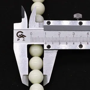 Macro shot of 8mm natural stone beads measured by a caliper on black background