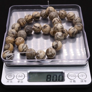 Detailed top view of natural labradorite round beads weighing 80.0g on a digital scale