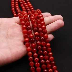 Polished red dragon vein agate round beads for DIY jewelry making held in hand
