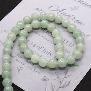 Green aventurine stone beads arranged in an S-curve on card for DIY jewelry