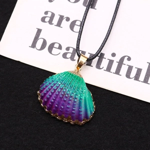 Detail of gradient sea shell pendant with gold plated edges and black wax cord necklace