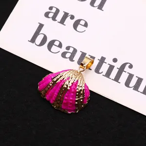 Macro detail of a pink enamel shell pendant with a gold-plated metallic edge finish