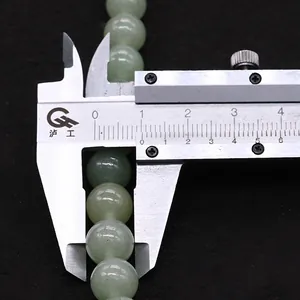 Vista dettagliata di perle in avventurina verde da 8 mm misurate con un calibro di precisione