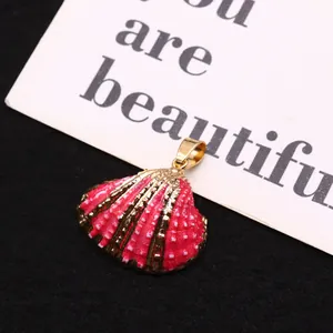 Polished hot pink shell pendant with white polka dots and gold-plated metal edges