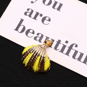 Natural yellow sea shell snail pendant with electroplated gold edge and metal loop
