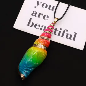 Macro detail of rainbow gradient spiral seashell pendant with elegant gold plated trim