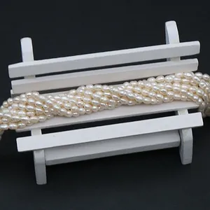 Natural white freshwater rice pearls on a white mini bench with a dark background