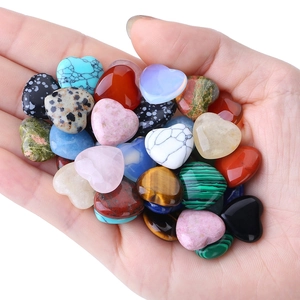 Polished heart-shaped natural crystal stones held in hand for DIY jewelry making