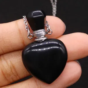 Macro shot of heart-shaped black obsidian gemstone perfume bottle pendant with silver chain