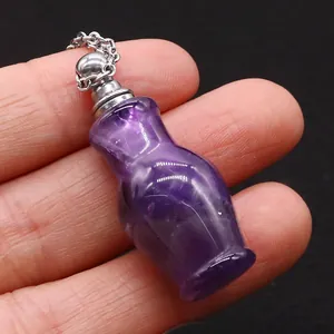 Détail macro d'un petit pendentif flacon de parfum en améthyste avec bouchon argenté