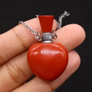 Macro detail of a heart-shaped red agate perfume bottle pendant with silver metal cap