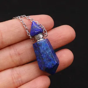 Detailansicht einer Lapis-Lazuli-Parfümflaschen-Halskette in der Hand vor schwarzem Grund