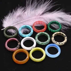 Polished natural agate and crystal stone rings in diverse colors on black surface