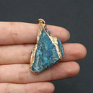 Macro detail van onregelmatige blauwe lapis lazuli hanger met vergulde gouden randen