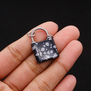 Close-up of snowflake obsidian lock pendant with handmade silver wire wrapping detail