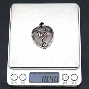 Detailed top view of a heart-shaped dragon pendant weighing 18.40g on a scale