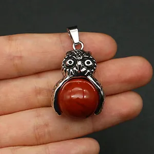 Dettaglio macro del ciondolo a forma di gufo in argento antico con diaspro rosso