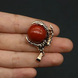 Detailed view of golden dragon claw pendant holding a round red stone for DIY jewelry