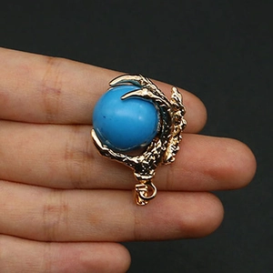 Macro shot of gold dragon claw pendant holding a blue stone for DIY necklace jewelry
