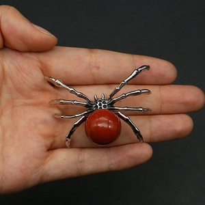 Macro view of spider pendant featuring a large red agate stone set in silver metal