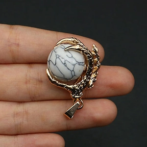 Detailed view of a gold-plated dragon claw pendant holding a textured marble stone sphere