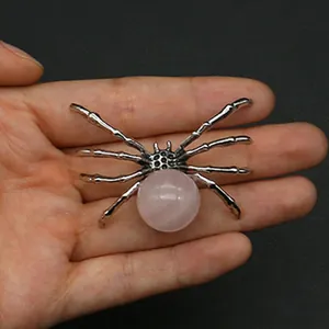 Detailed view of spider pendant featuring a pink quartz stone and silver vintage metal frame
