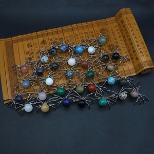 Vintage spider-shaped natural stone pendants with various gemstones on black leather background