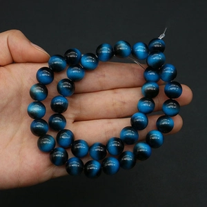 Macro shot of 8-10mm deep blue tiger eye glass beads with cat eye effect for DIY jewelry