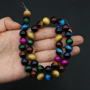 Macro detail of mixed color round glass beads with tiger eye texture for DIY jewelry making