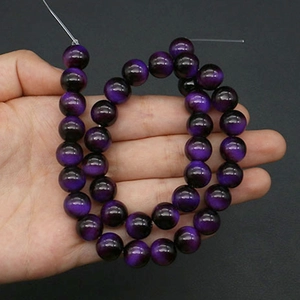 Macro shot of 10mm purple cat eye glass beads for DIY jewelry making and craft projects