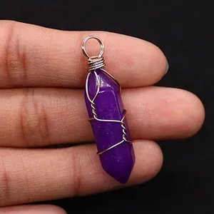 Macro detail of purple hexagonal crystal stone pendant wrapped in silver wire