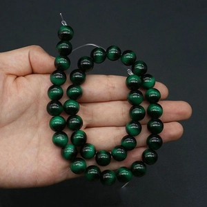 Detailed view of dark green tiger eye glass beads with cat-eye effect for jewelry making