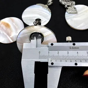 Detailed measurement of white mother of pearl pendant thickness with a caliper