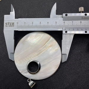 Medición del colgante de nácar natural de 5,8 cm con un calibre de precisión