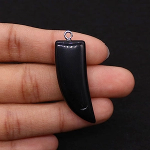 Ciondolo in pietra nera lucida a forma di corno con anello metallico d'argento in mano