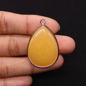 Detailed close-up of a drop-shaped yellow stone pendant with silver metal plating