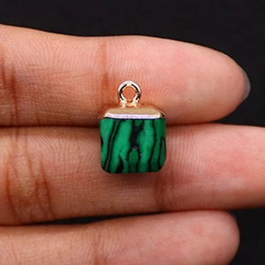 Detailed view of a green malachite square stone pendant held to show compact size