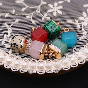 Set of six colorful cube gemstone pendants with gold plated caps on lace background