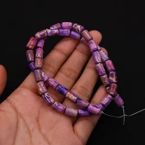 Gros plan de perles cylindriques en pierre impériale violette avec texture naturelle marbrée