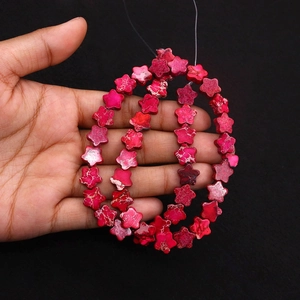 Macro detail of star-shaped rose red jasper loose beads for DIY jewelry making