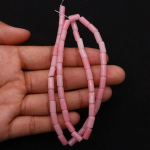 Close-up of pink cylindrical natural stone beads on a string for jewelry making