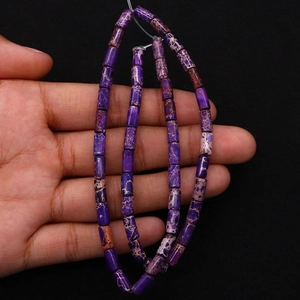 Macro shot of purple cylindrical emperor stone beads with natural mineral texture for DIY